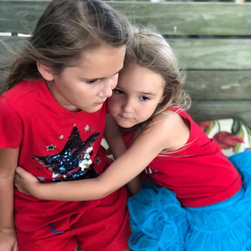 sisters hugging at lake